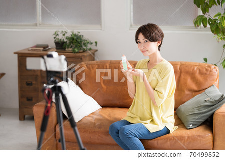 一個在鏡頭前播放推薦化妝品視頻的女人 一個在鏡頭前播放推薦化妝品視頻的女人 70499852