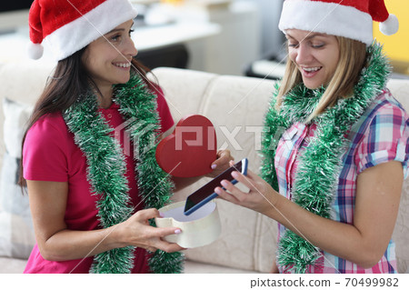 Surprised girlfriend open gift and take out phone. Surprised girlfriend open gift and take out phone. 70499982
