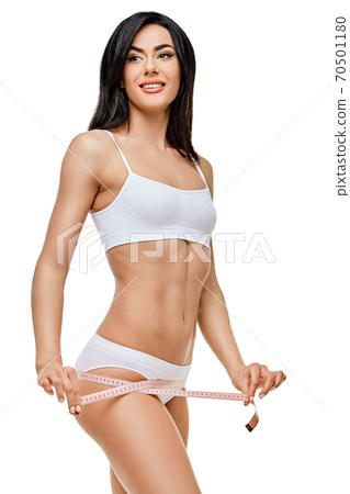 Slim tanned woman's body isolated on white background - waist measurement 70501180