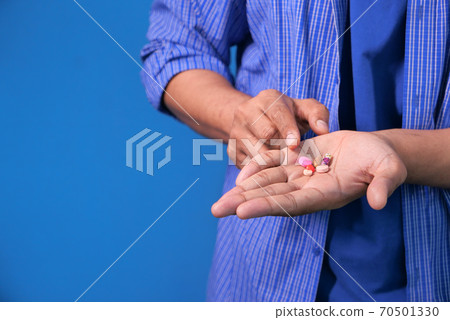 Close up of man hand taking medicine  70501330