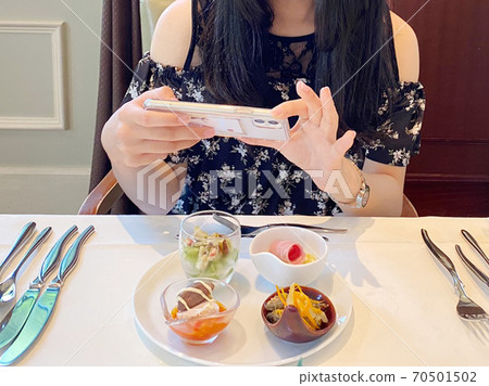一位用智能手機拍攝以Instagram外觀為目標的女人 70501502