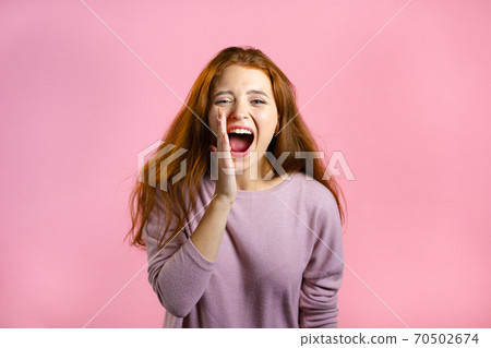 Woman with red hair very glad, she screaming loud. Woman trying to get attention. Concept of sales 70502674