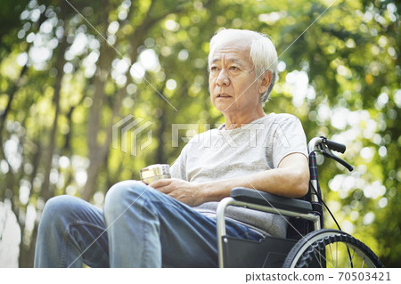 sad asian old man sitting in wheel chair outdoors sad asian old man sitting in wheel chair outdoors 70503421