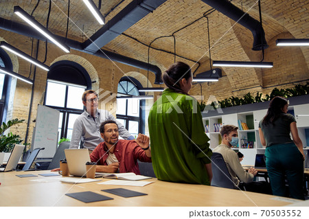 Group of happy multiracial business people talking, communicating while working together in the modern office or coworking space Group of happy multiracial business people talking, communicating while working together in the modern office or coworking space 70503552