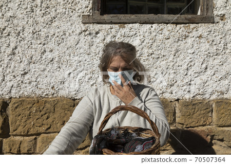 A senior woman, correctly adjusts her protective face mask, Spain A senior woman, correctly adjusts her protective face mask, Spain 70507364
