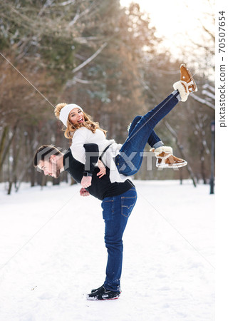 young loving couple on natural winter background. New Year and Christmas. 70507654