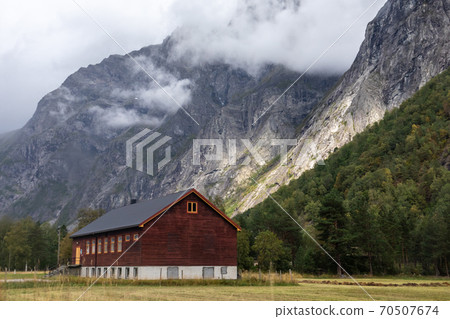 Wooden house in village countryside rocky hills. Mountains near Andalsnes in Norway Wooden house in village countryside rocky hills. Mountains near Andalsnes in Norway 70507674