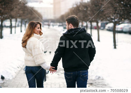 young loving couple on natural winter background. New Year and Christmas. young loving couple on natural winter background. New Year and Christmas. 70508029