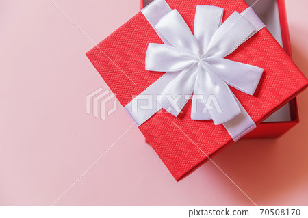 Christmas New Year birthday valentine celebration present romantic concept. Simply minimal design red gift box isolated on pastel pink colorful background. Flat lay top view, copy space Christmas New Year birthday valentine celebration present romantic concept. Simply minimal design red gift box isolated on pastel pink colorful background. Flat lay top view, copy space 70508170