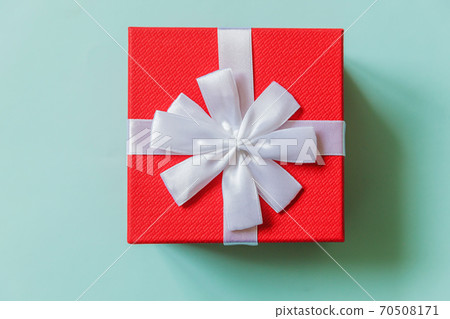 Christmas New Year birthday valentine celebration present romantic concept. Simply minimal design red gift box isolated on pastel blue colorful background. Flat lay top view, copy space Christmas New Year birthday valentine celebration present romantic concept. Simply minimal design red gift box isolated on pastel blue colorful background. Flat lay top view, copy space 70508171