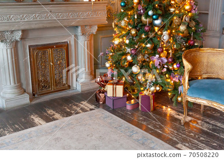 Classic christmas New Year decorated interior room fireplace New year tree. Christmas tree with gold ornament decorations. Modern classical style interior design apartment. Christmas eve at home. Classic christmas New Year decorated interior room fireplace New year tree. Christmas tree with gold ornament decorations. Modern classical style interior design apartment. Christmas eve at home. 70508220