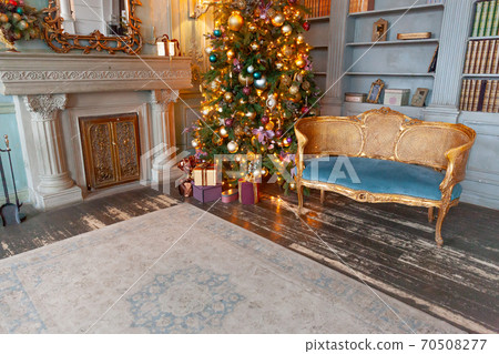 Classic Christmas New Year decorated interior room home library with fireplace. Christmas tree with gold ornament decorations. Modern classical style interior design apartment. Christmas eve at home. Classic Christmas New Year decorated interior room home library with fireplace. Christmas tree with gold ornament decorations. Modern classical style interior design apartment. Christmas eve at home. 70508277
