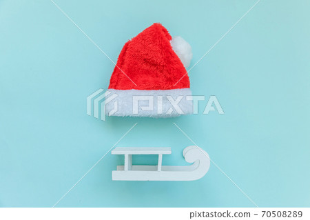 Simply minimal composition Christmas Santa Claus hat sled isolated on blue pastel colorful trendy background Simply minimal composition Christmas Santa Claus hat sled isolated on blue pastel colorful trendy background 70508289