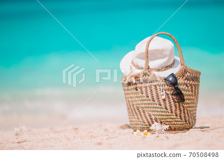 Beach accessories - straw bag, hat and unglasses on the beach 70508498