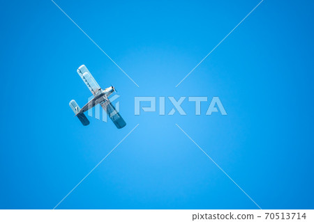 Retro green biplane plane in the blue sky 70513714
