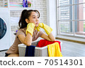 woman frustrated with washing clothes 70514301