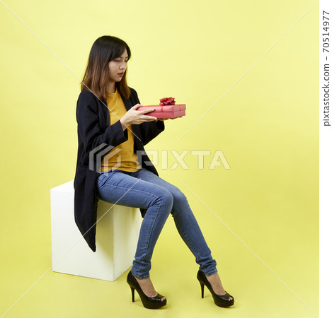 Young woman holding a gift box 70514977