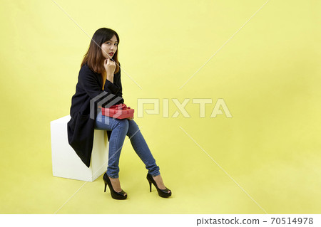 Young woman holding a gift box Young woman holding a gift box 70514978