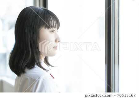 A woman looking out through the window A woman looking out through the window 70515167