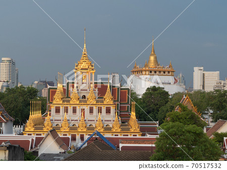 Loha Prasat Wat Ratchanatda and Golden Mountain pagoda, a buddhist temple or Wat Saket with skyscraper buildings in Bangkok Downtown, urban city, Thailand. Thai Landmark. Architecture. 70517532