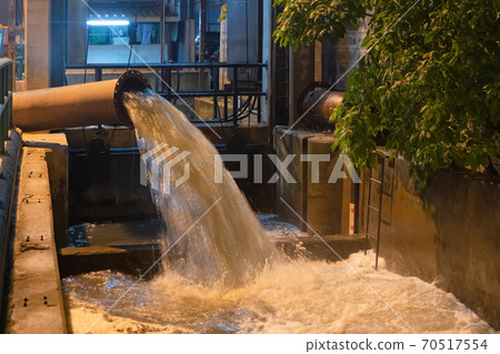 A drain pipe tube, sewage or sewage discharges waste water into a river from factory industry. Water flowing in pollution concept. 70517554