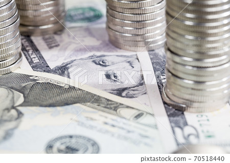silver-colored metal coins stacked together on American dollars silver-colored metal coins stacked together on American dollars 70518440