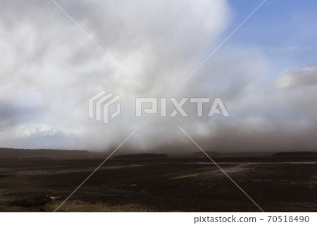 dust from peat excavations flying against the sky dust from peat excavations flying against the sky 70518490