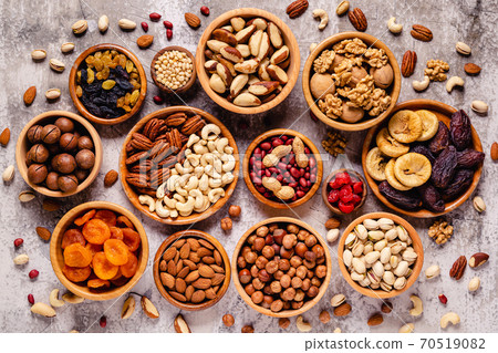 Various Nuts and dried fruits in wooden bowls. 70519082