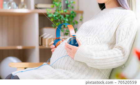 Pregnant woman with headphones on her belly 16:9 Pregnant woman with headphones on her belly 16:9 70520559