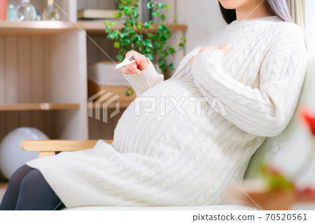 Pregnant woman measuring body temperature 70520561