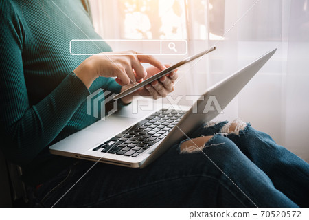 Female clicking internet search page on computer and tablet touch screen in office. 70520572