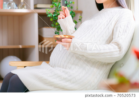 Pregnant women eating cashew nuts Mixed nuts diet 70520573