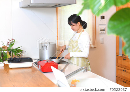 Woman cooking in the kitchen Woman cooking in the kitchen 70522987