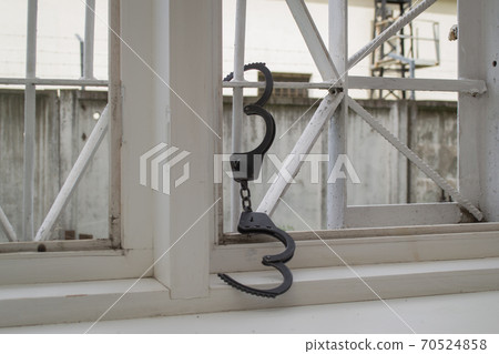 Open handcuffs hang on the cage. Successful escape exemption	 70524858