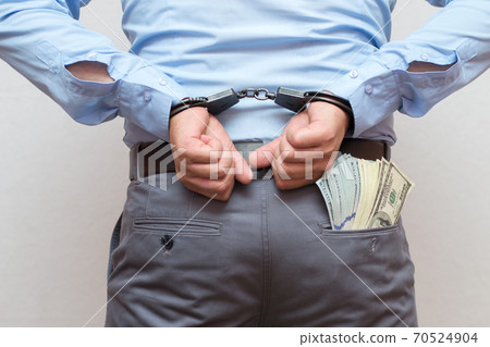 Corruption and bribery concept - arrested official with money in hands on white background Corruption and bribery concept - arrested official with money in hands on white background 70524904
