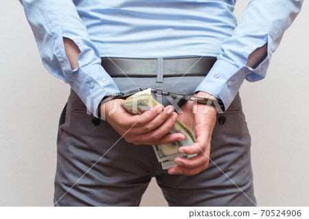 Corruption and bribery concept - arrested official with money in hands on white background Corruption and bribery concept - arrested official with money in hands on white background 70524906