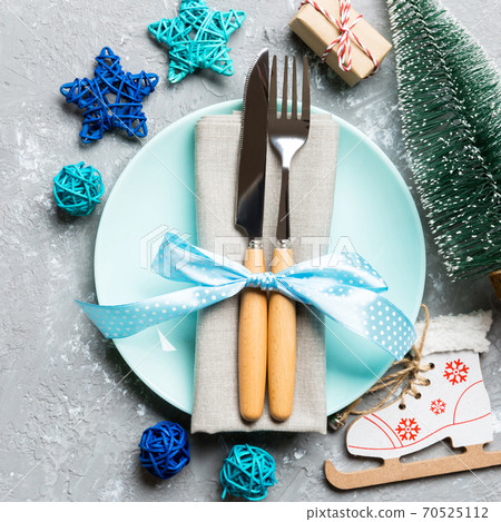 Holiday composition of Christmas dinner on cement background. Top view of plate, utensil and festive decorations. New Year Advent concept with copy space Holiday composition of Christmas dinner on cement background. Top view of plate, utensil and festive decorations. New Year Advent concept with copy space 70525112