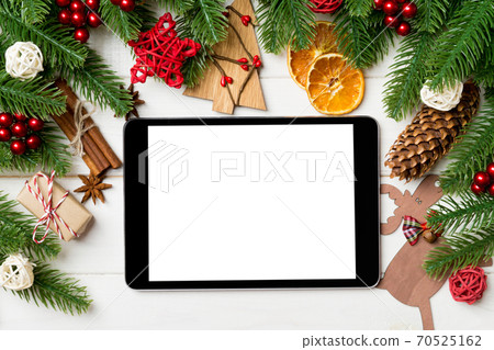 Top view of fir tree branches and festive decorative toys on wooden background. New Year time concept with empty space for your design Top view of fir tree branches and festive decorative toys on wooden background. New Year time concept with empty space for your design 70525162