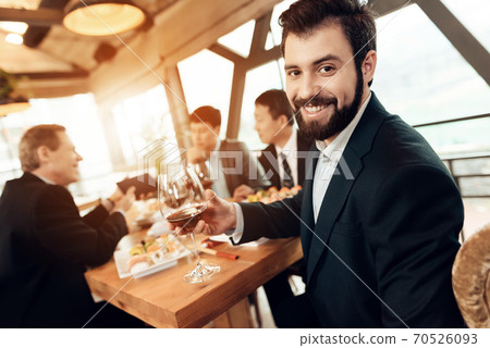 A man in a suit with a glass of wine. A man in a suit with a glass of wine. 70526093