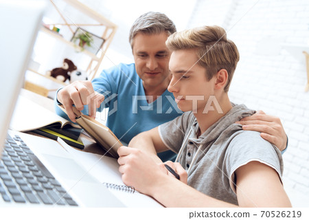 Dad helps his son learn homework. Dad helps his son learn homework. 70526219