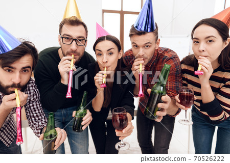 Cheerful team are blowing in holiday tricks. Cheerful team are blowing in holiday tricks. 70526222