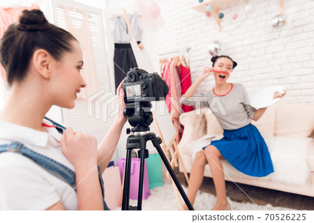 Girls hold up brush with one girl behind camera. 70526225