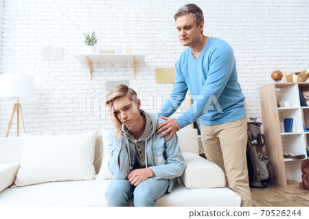 Son offended by dad turned away and is sad. Son offended by dad turned away and is sad. 70526244