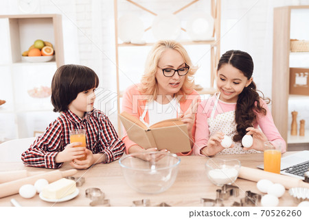 Grandmother and grandchildren prepare a new recipe Grandmother and grandchildren prepare a new recipe 70526260