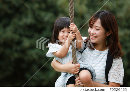 Parents and children playing with Tarzan rope 70526463