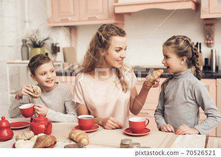 Family is drinking tea with croissants. Family is drinking tea with croissants. 70526521