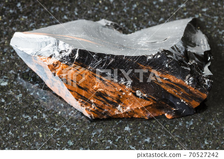 unpolished mahogany Obsidian on black granite 70527242