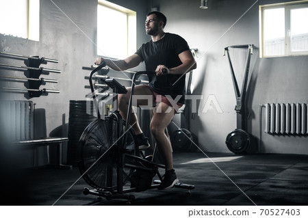 Sportsman Train His Legs Muscles on Stationary Bike . Sportsman Train His Legs Muscles on Stationary Bike . 70527403