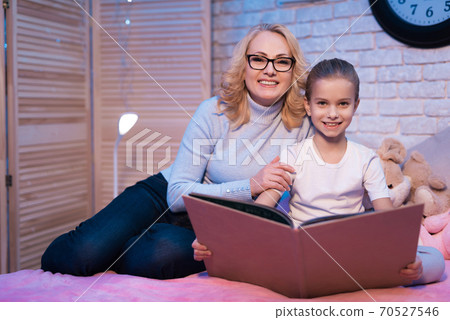 Grandmother and granddaughter looking at camera. Grandmother and granddaughter looking at camera. 70527546
