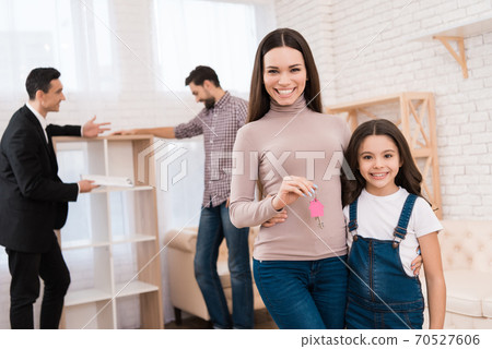 Mom hugs daughter and holds key to new apartment. Mom hugs daughter and holds key to new apartment. 70527606